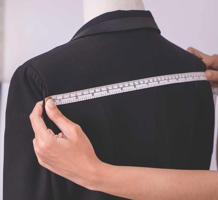 Măsurarea unui sacou pe manechin în atelier
