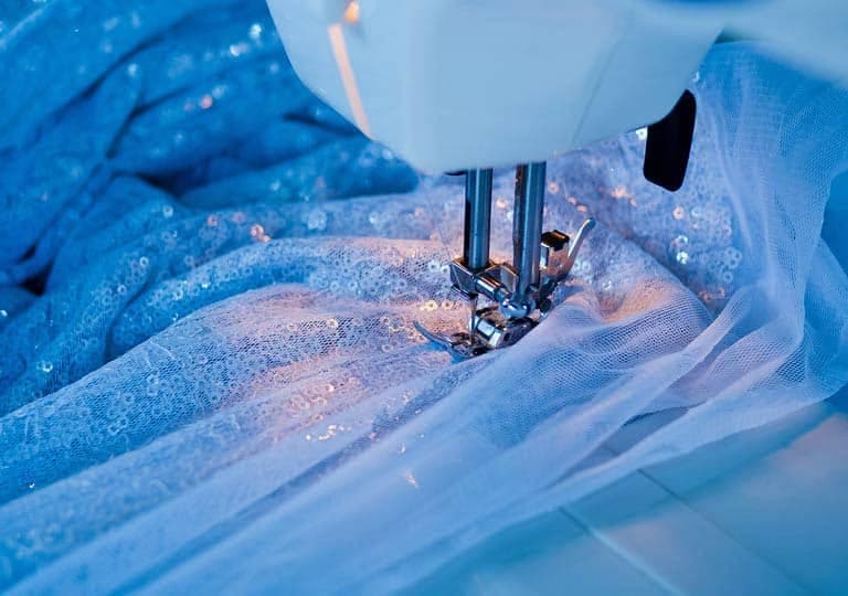 Mașină de cusut lucrând pe material fin cu paiete, atelier Elena Negrei
